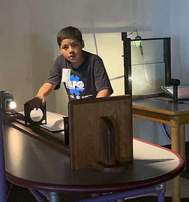 boy learning to use manufacturing equipment