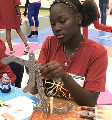 girl learning about manufacturing at a workshop