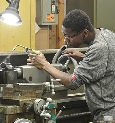 young man working with manufacturing equipment