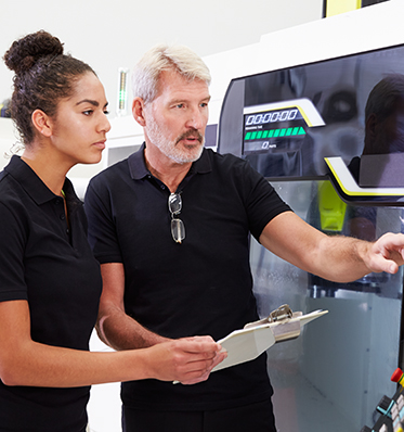 a man and a woman working with manufacturing equipment