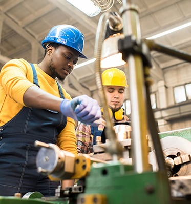 two men working with manufacturing equipment